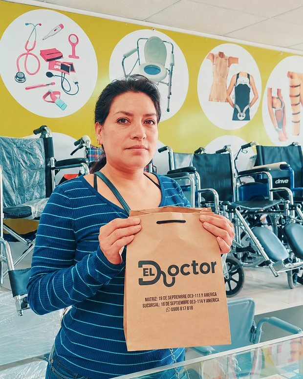 Una clienta con su compra, junto a las sillas de ruedas del local